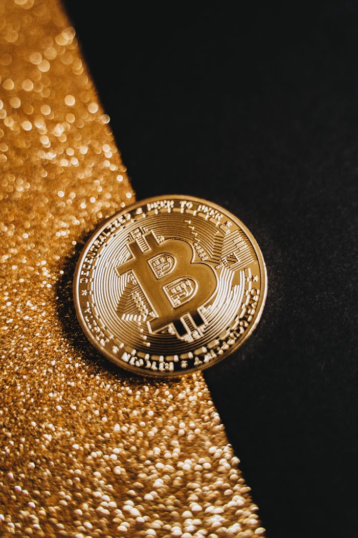 Close-up of a Bitcoin resting on a glittering gold surface, symbolizing wealth and digital currency.