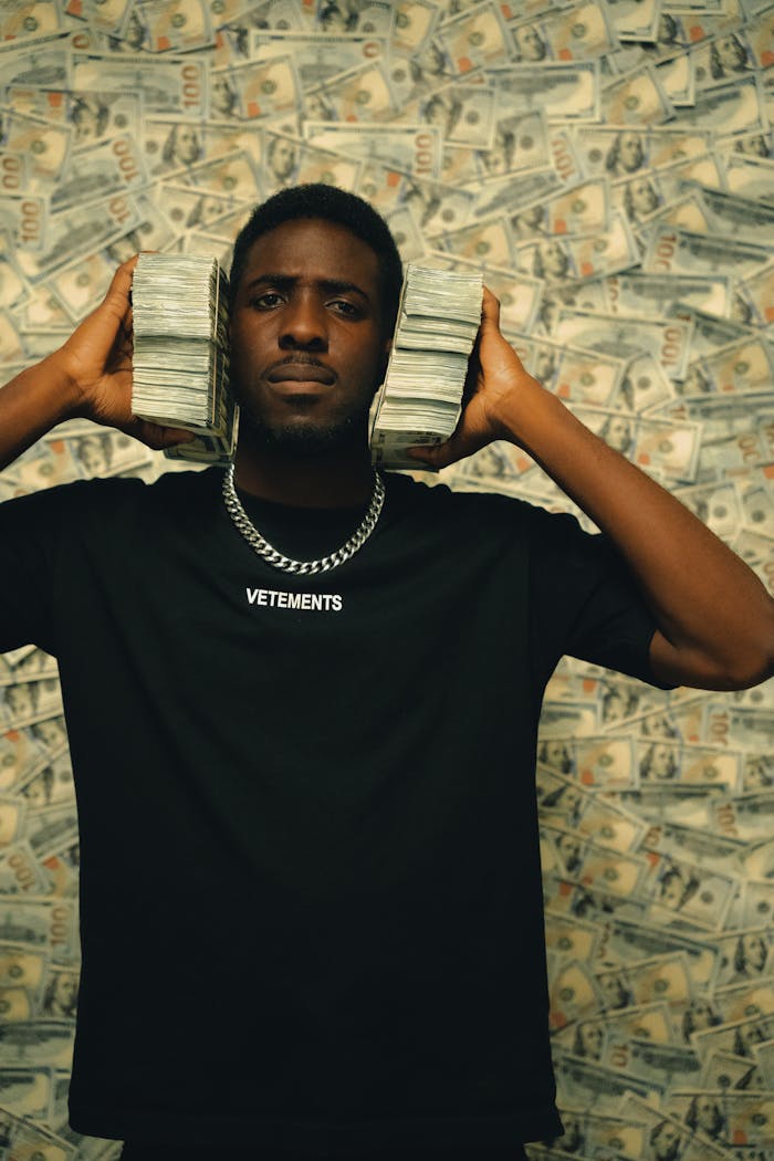 Portrait of a man holding money stacks with a money background, symbolizing wealth.